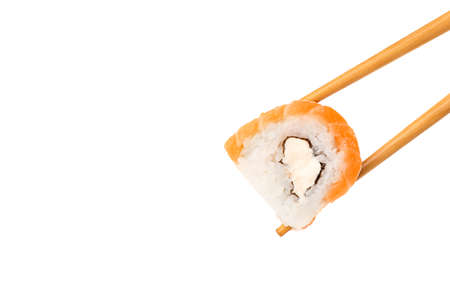 Chopsticks taking delicious sushi roll with salmon and philadelphia cheese on white backgroundの写真素材