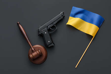 Judge's gavel, gun and flag of Ukraine on black backgroundの写真素材