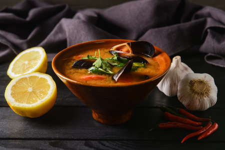 Bowl of spicy Thai soup on dark wooden backgroundの写真素材