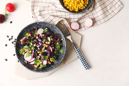 Bowl of Mexican vegetable salad with black beans and radish on light backgroundの写真素材