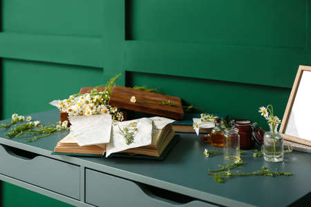 Book with dried chamomiles on tableの写真素材