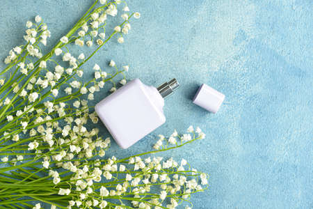 Bottle of perfume and lily-of-the-valley flowers on color backgroundの写真素材