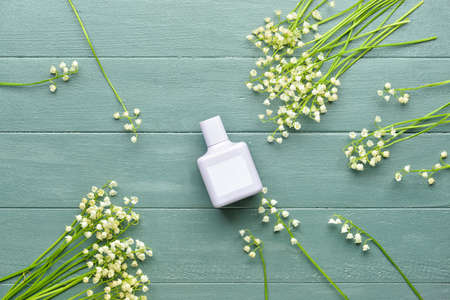 Bottle of perfume and lily-of-the-valley flowers on gray wooden backgroundの写真素材