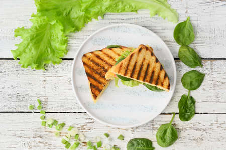 Plate with tasty sandwiches on light wooden backgroundの写真素材