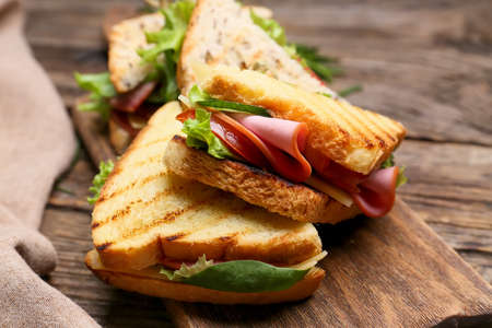 Board with tasty sandwiches on wooden background, closeupの写真素材