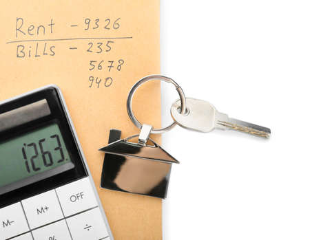House key with keychain, rent and bills calculations on white background, closeupの写真素材
