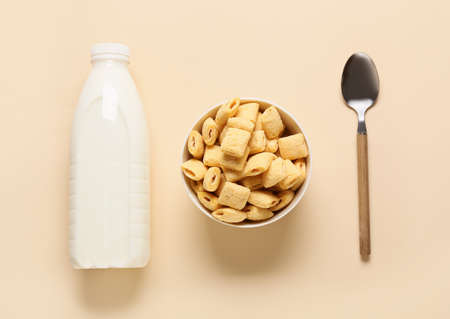Bowl with tasty corn pillows and milk on color backgroundの写真素材