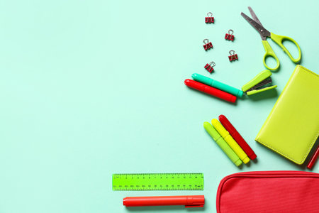Pencil case with stationery on color background