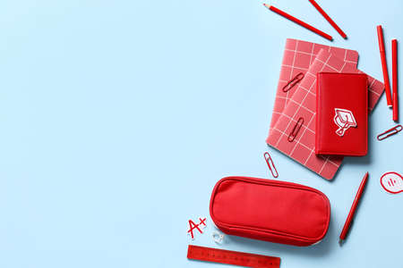 Pencil case with stationery on color background