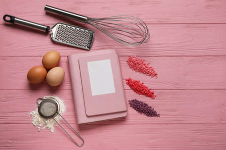 Recipe book, ingredients and kitchen utensils on color wooden backgroundの写真素材