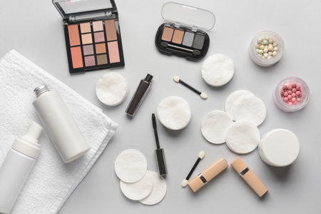Different cosmetics, towel and cotton pads on light backgroundの写真素材