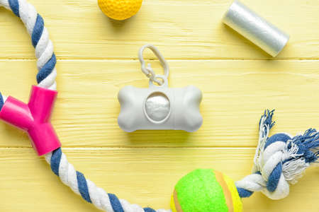 Dispenser with pet waste bags and toys on color wooden background, closeupの写真素材