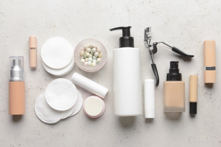 Different decorative cosmetics and cotton pads on light backgroundの写真素材