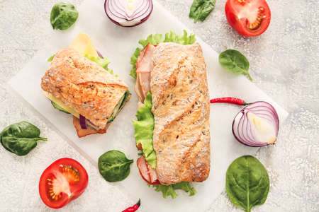 Tasty ciabatta sandwiches on light background