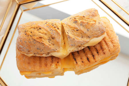 Tray with cheese ciabatta sandwiches on light background