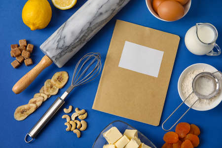Recipe book with products on color background
