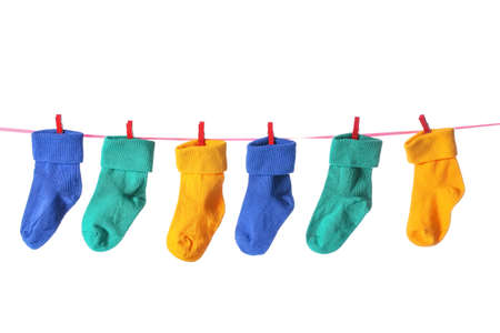 Rope with colorful baby socks on white background
