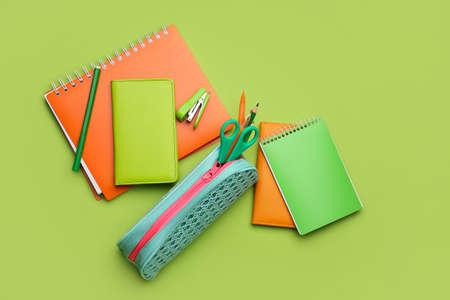 Pencil case and stationery on color background