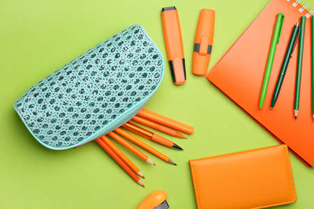 Pencil case and stationery on color background