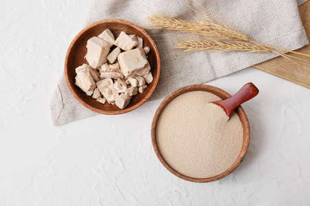 Bowls with fresh and dry yeast on light background