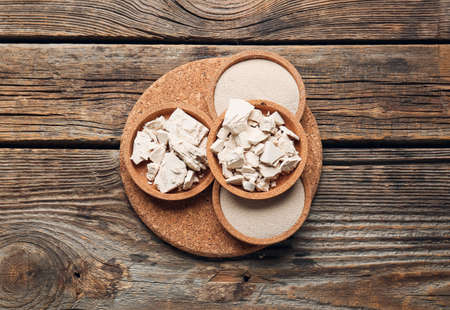 Board with fresh and dry yeast on wooden backgroundの写真素材