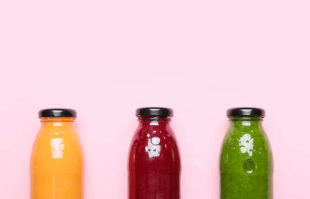 Bottles of healthy smoothies on color backgroundの写真素材