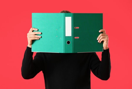 Young man with folder on color backgroundの写真素材