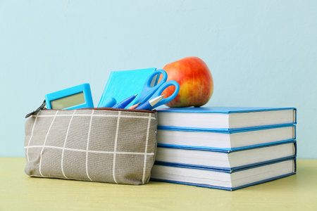 Pencil case and stationery on color background