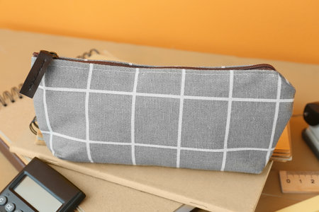 Pencil case and stationery on color background