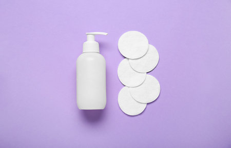 Bottle of cosmetic product and cotton pads on color backgroundの写真素材