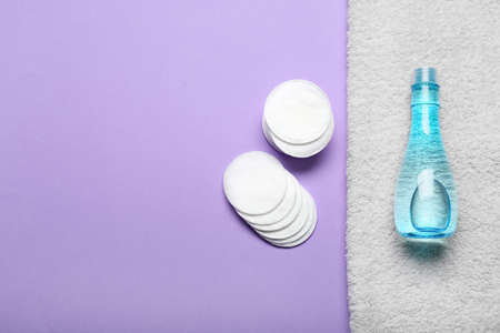 Cotton pads and bottle of cosmetic product on purple backgroundの写真素材