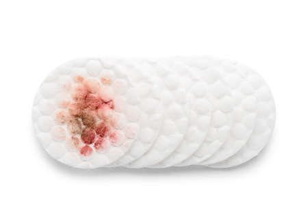 Used dirty cotton pads on white background