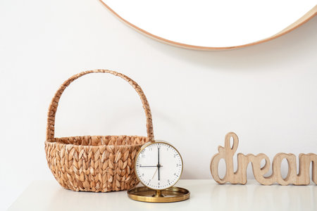 Golden alarm clock with wicker basket on tableの写真素材