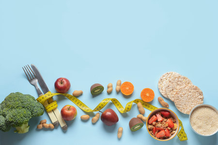 Composition with healthy products, cutlery and measuring tape on color backgroundの写真素材