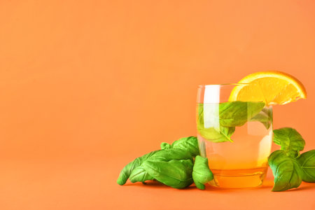 Glass of tasty lemonade with basil on color backgroundの写真素材