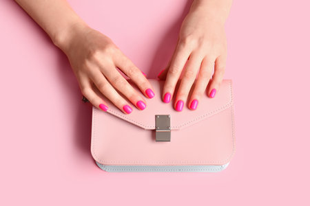 Woman with beautiful manicure and bag on color backgroundの写真素材