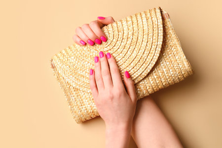 Woman with beautiful manicure and bag on color backgroundの写真素材