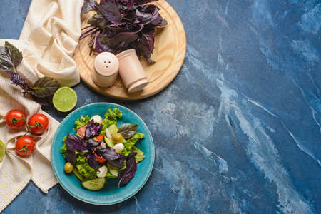 Composition with tasty fresh salad and spices on color backgroundの写真素材
