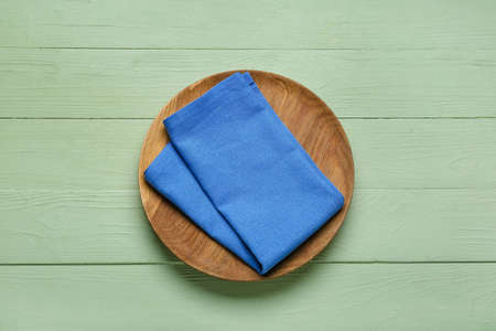 Plate with napkin on color wooden backgroundの写真素材