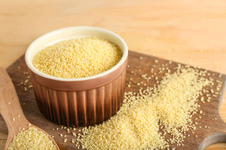 Bowl of raw couscous on table