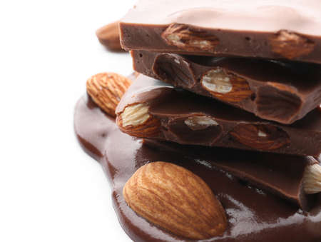 Pieces of tasty chocolate with almonds on white background, closeupの写真素材