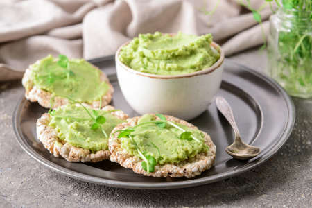 Tray with crispbreads and tasty pea hummus on grunge backgroundの写真素材
