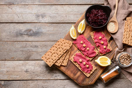 Crispbreads with tasty beetroot hummus on wooden backgroundの写真素材