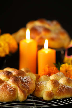 Bread of the dead and candles on dark background. Celebration of Mexico's Day of the Dead (El Dia de Muertos)の写真素材