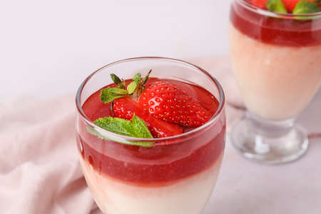 Glass with tasty strawberry panna cotta on table, closeupの写真素材