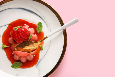 Plate with tasty homemade strawberry panna cotta on pink background