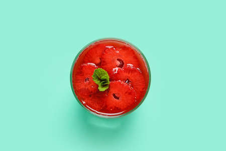 Delicious homemade panna cotta with strawberry and mint on color background