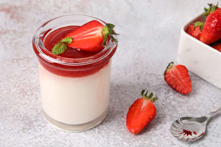 Glass with delicious strawberry panna cotta on light background, closeupの写真素材