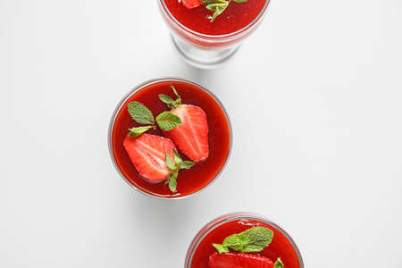 Tasty homemade panna cotta with strawberry in glasses on white backgroundの写真素材