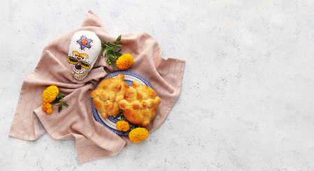 Bread of the dead and painted skull on light background. Celebration of Mexico's Day of the Dead (El...